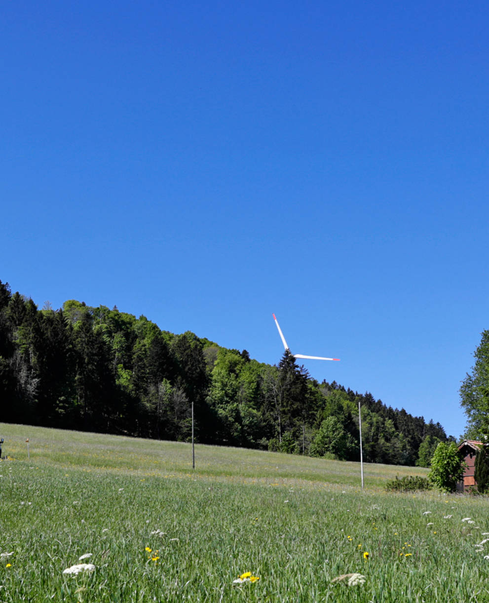 Sur les crêtes du Jura, des éoliennes majestueuses se dressent vers le ciel